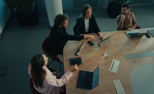 2 weibliche und 2 männliche Mitarbeiter:innen sitzen am Konferenztisch und haben ein Meeting.