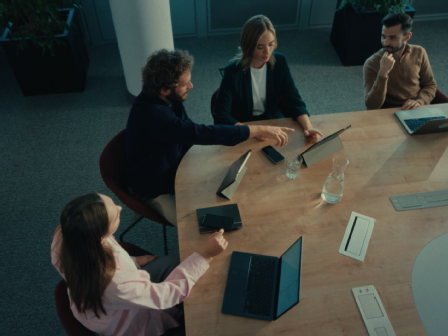 2 weibliche und 2 männliche Mitarbeiter:innen sitzen am Konferenztisch und haben ein Meeting.