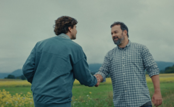 APG Grundstücksmanager und Grundstücksbesitzer begrüßen sich mit Handschlag auf einem Feld.