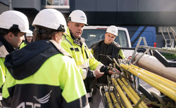 APG-Mitarbeiter vor Stromleitungsbauteilen